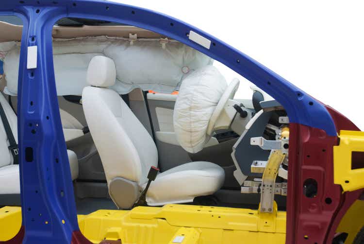 A modern car showing the airbag inside, cut in half with the track