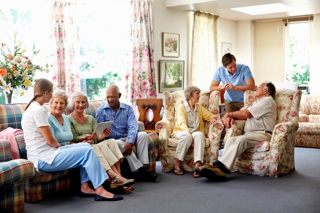 Caretaker with retired people in nursing home