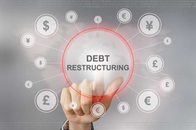 business hand pushing debt restructuring button