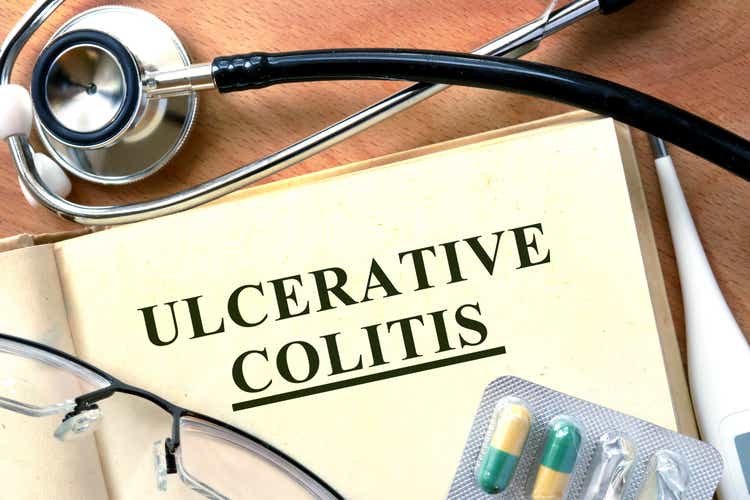 Ulcerative colitis concept. Book with stethoscope and pills.