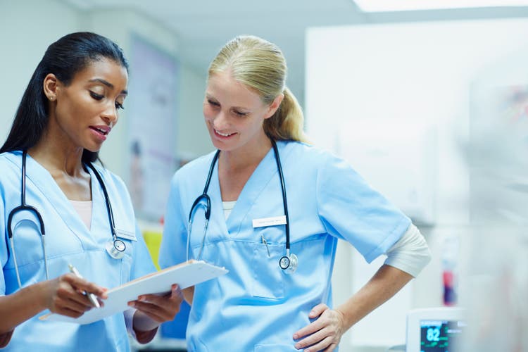 Nurses discussing over documents in hospital