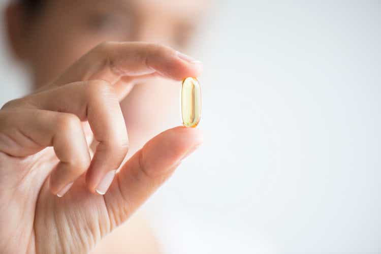 Woman Holding And Showing Omega 3 Capsule