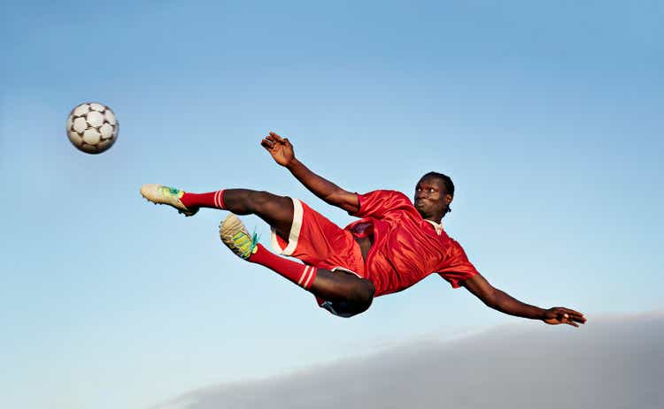 Football player about to kick ball in the air