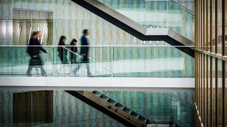 Businesspeople walking in office, blurred motion