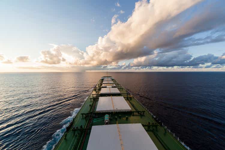 Cargo ship underway at sunset