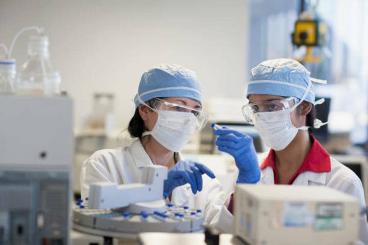 Scientists loading machinery in lab