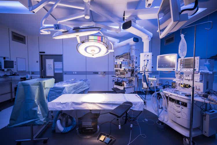 Empty hospital operating theatre with lighting over bed
