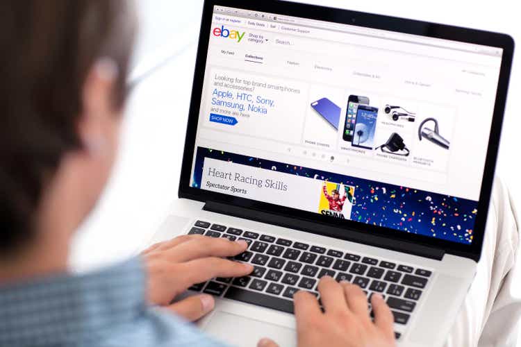 man sitting the MacBook retina with site PayPal on screen