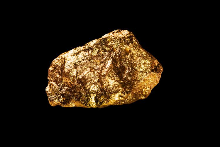 Gold nugget on black background.