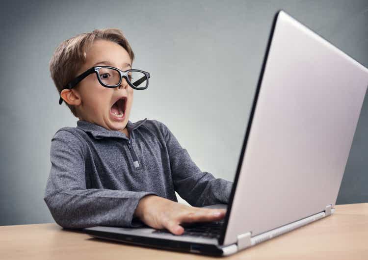 Shocked and surprised boy on the internet with laptop computer