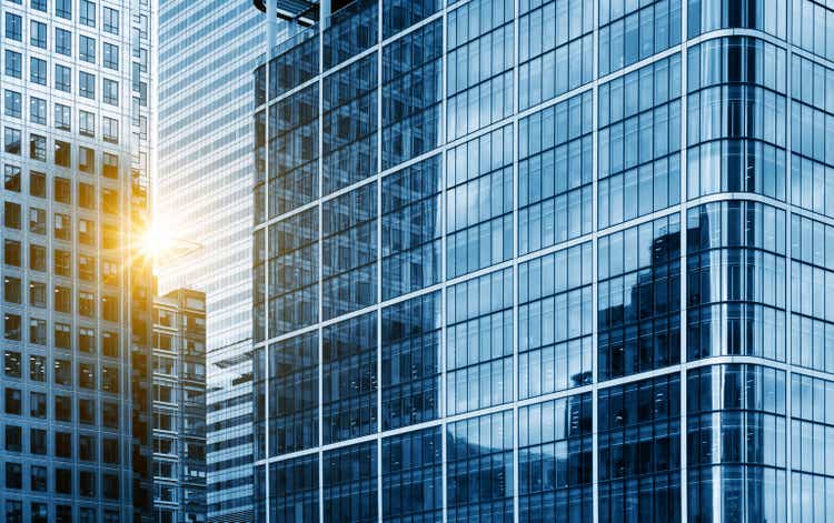 view of a contemporary glass skyscraper reflecting the blue sky