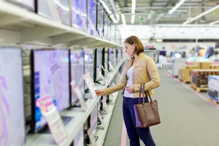 woman chooses a TV in the store