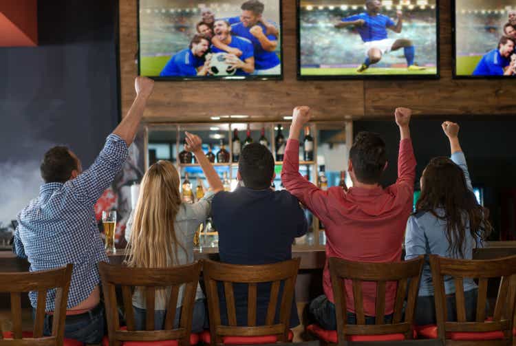 Excited group of people watching the game at a bar