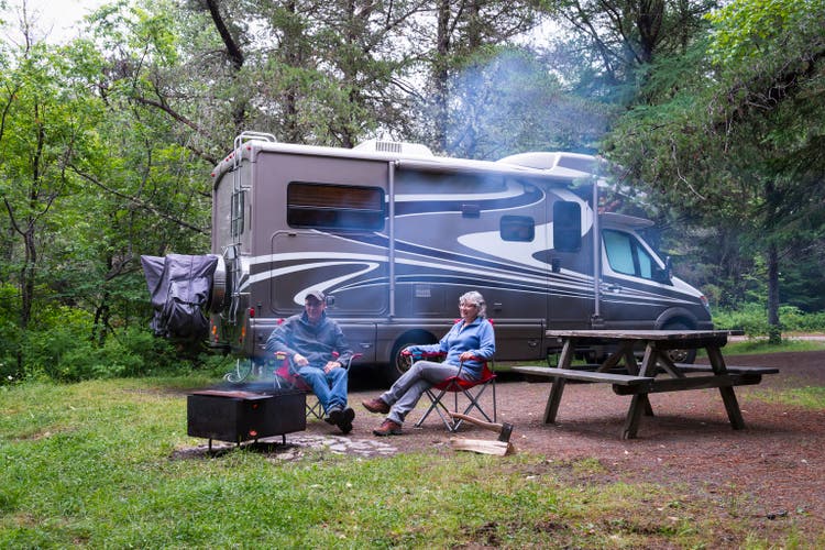Couple relaxing near campfire