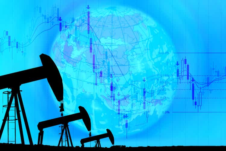 industrial pump jack and falling oil graph on globe background