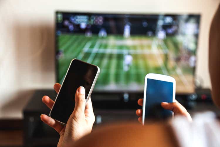 Friends using mobile phone during a tennis match