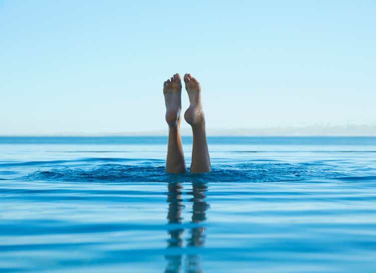 Feet of caucasian girl swimming in tropical ocean