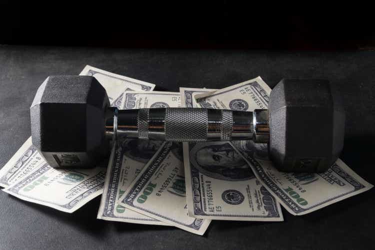 Metal dumbbell on money.