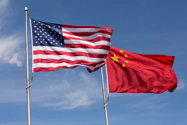 American Chinese windy day flags fly together on flagpole