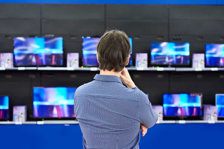Man looks at LCD TVs in store