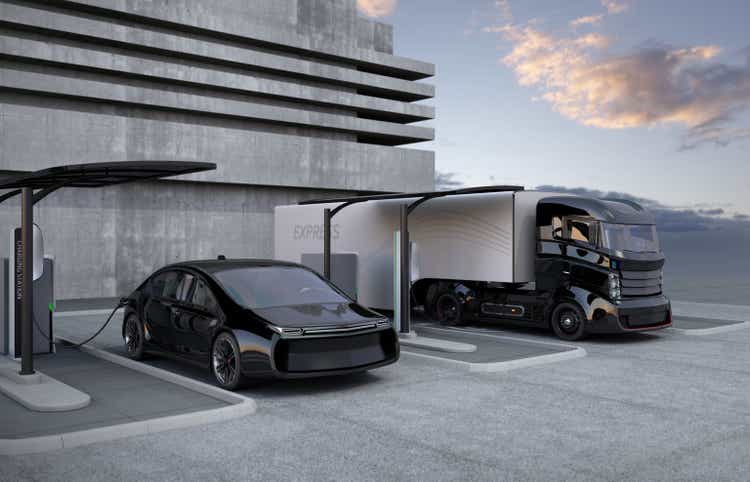 Hybrid electric truck and white electric car in charging station