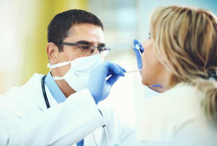 Doctor examining patient"s throat.