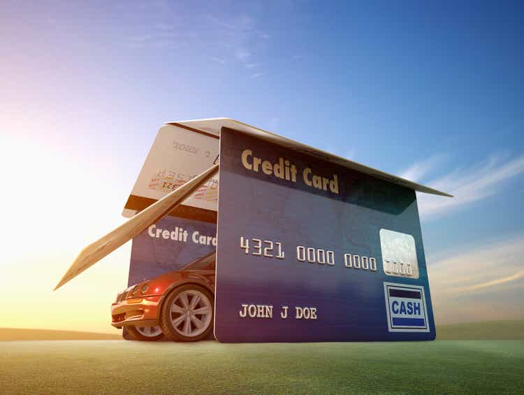 Car driving out of garage made of credit cards