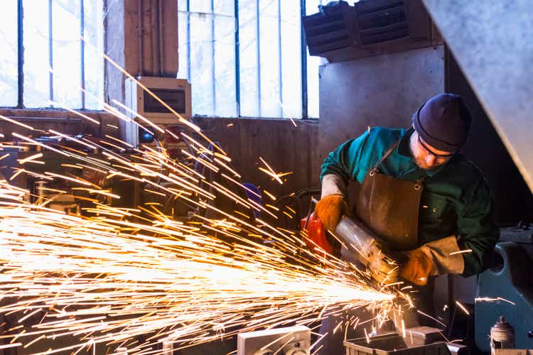 Worker with metal cutting grinder