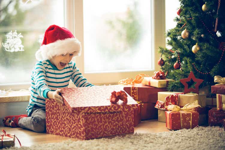 Surprised little boy opening Christmas present