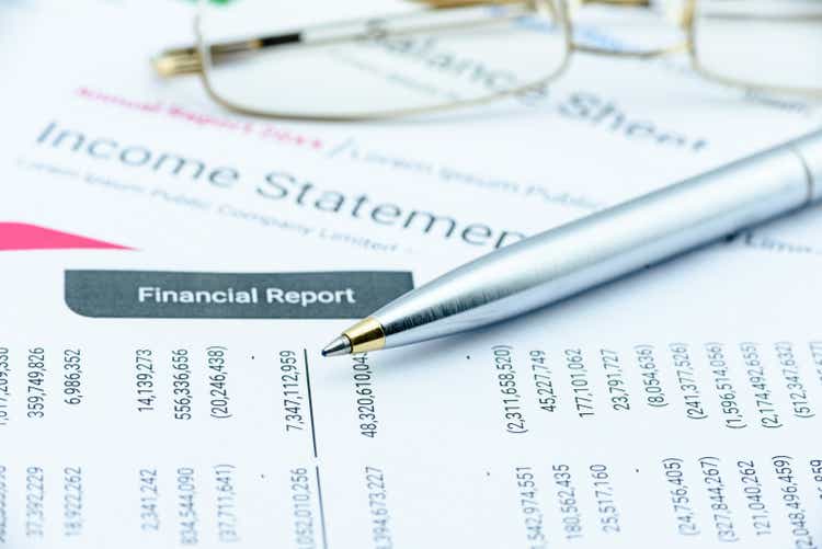 Blue ballpoint pen on a quarterly corporate financial report.