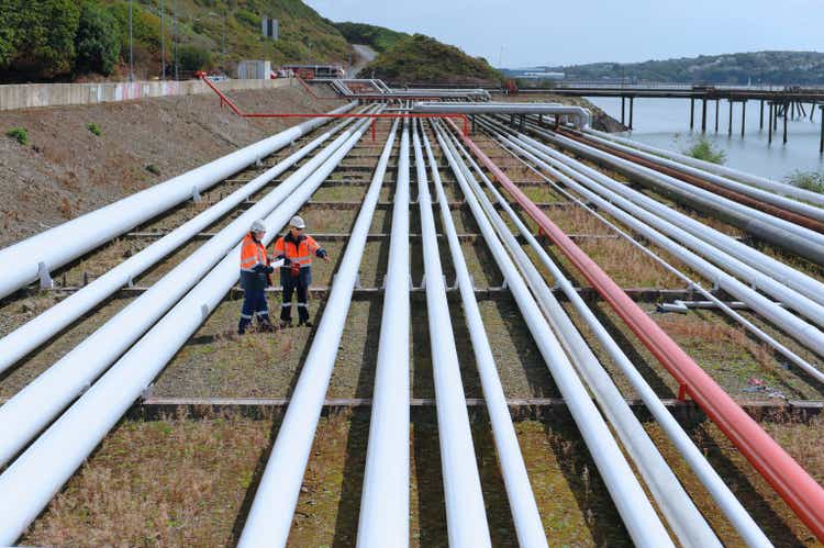 Caucasian technicians examining pipes