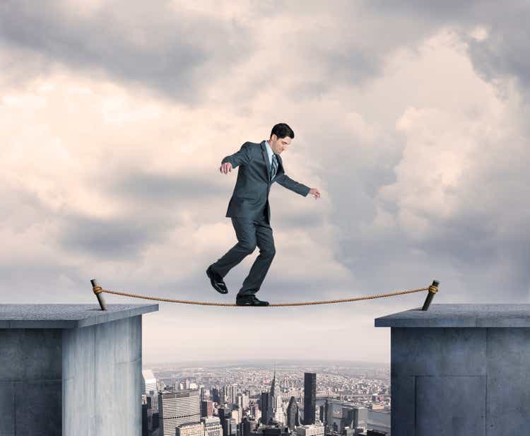 Businessman balancing on a tightrope above the big city