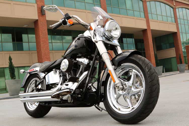 Custom motocicleta Harley aparqué fuera un complejo de oficinas