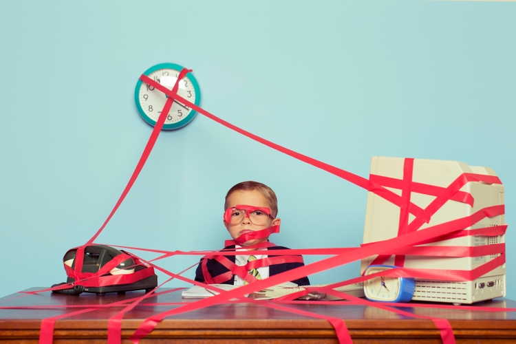 Young Boy in Business Office is Covered in Red Tape