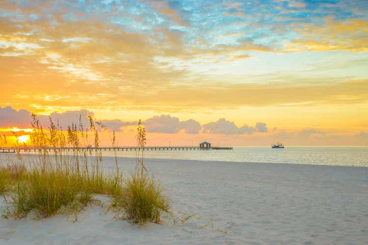 Gulfport Mississippi beach, dramtic golden sunrise, pier, shrimp boat, bay