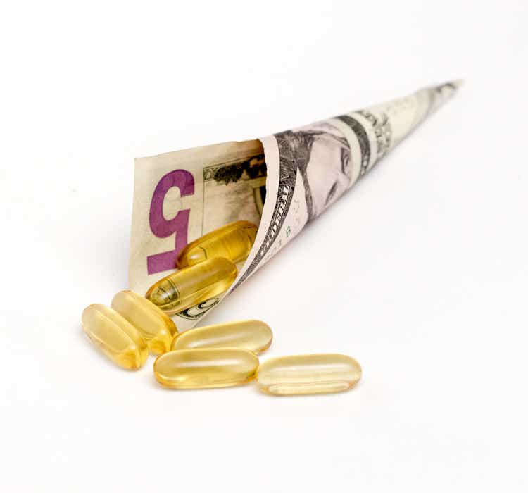 dollar bill and fish oil capsules