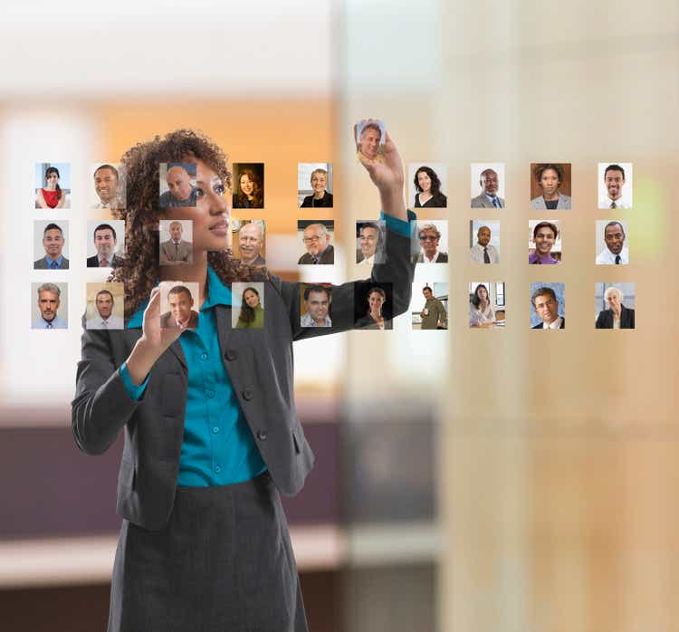 Businesswoman organizing photos of colleagues on touch screen