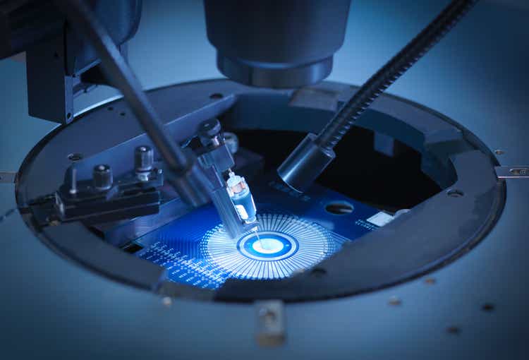 Machine checking silicon wafers in clean room lab, close up