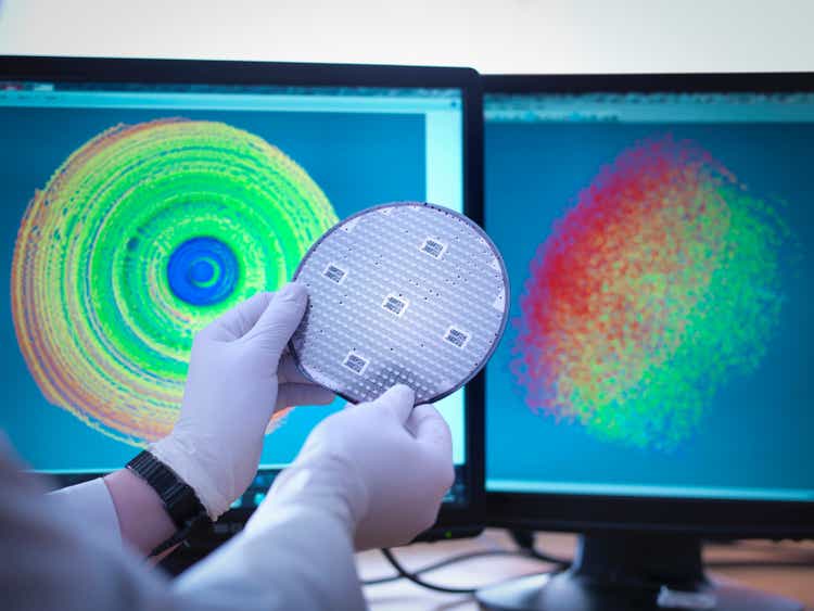 Scientist checking test map of silicon wafer in laboratory, close up