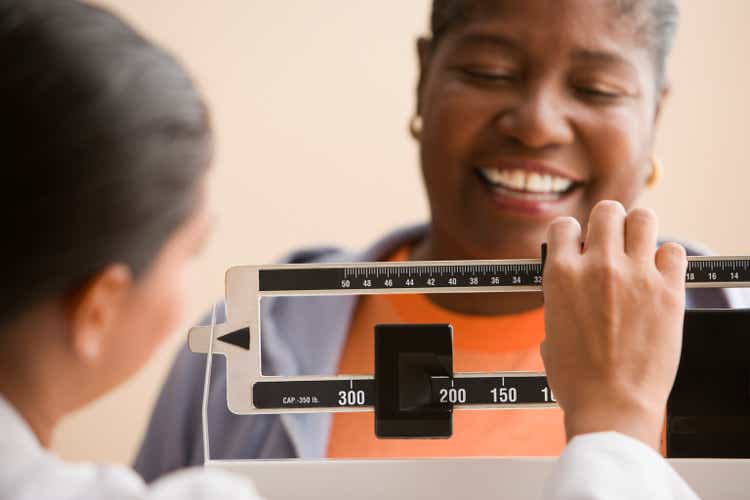 Doctor weighing woman