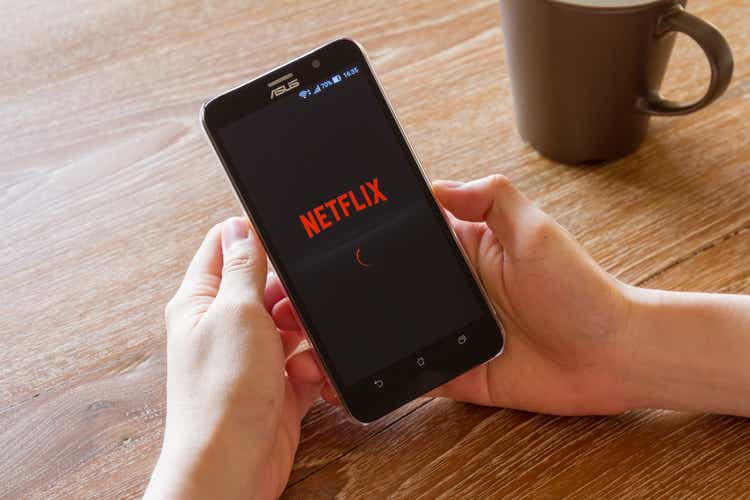 man hand holding screen shot of Netflix application