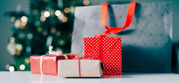 Shopping bag and christmas presents in front of christmas tree