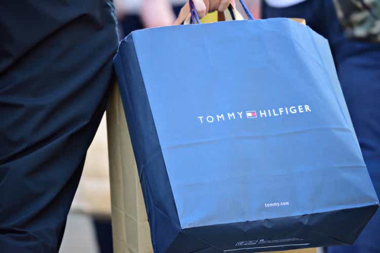 Person walking on sidewalk with Tommy Hilfiger shopping bag