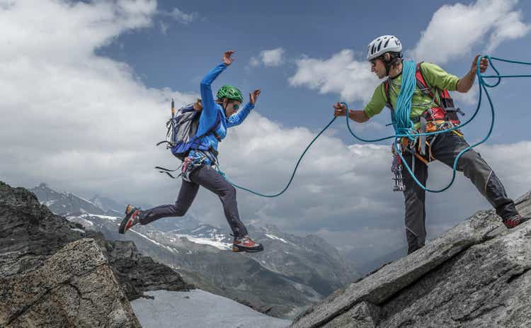 Female climber jumping between rocks