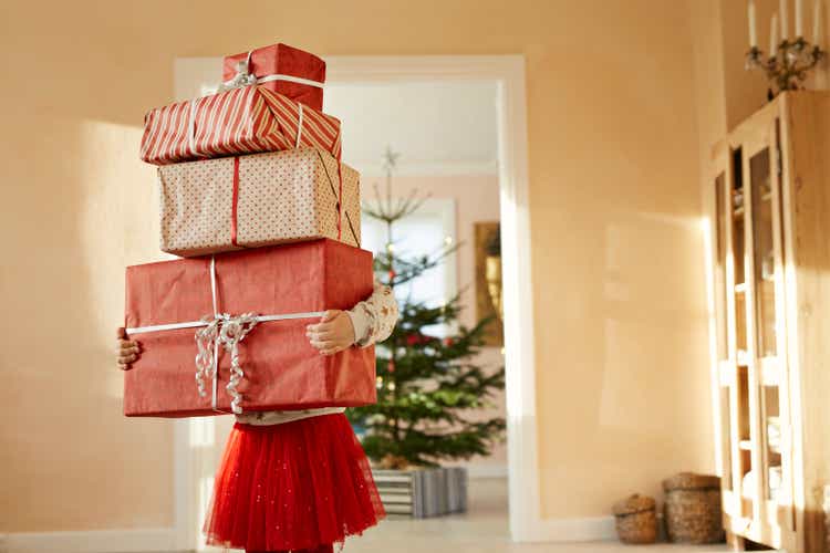 Girl holding tall stack of christmas presents