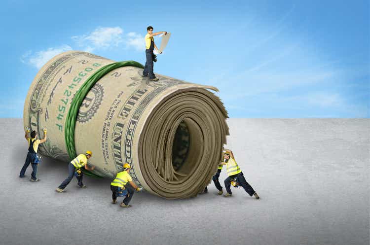 group of men rolling a bunch of dollar bills