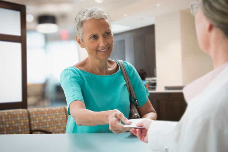 A woman handing over her insurance card at the hospital