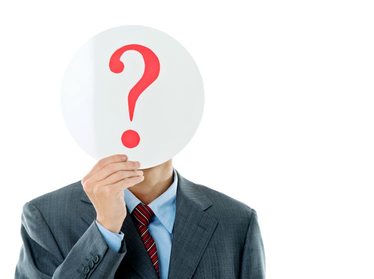 Confused businessman holding question mark