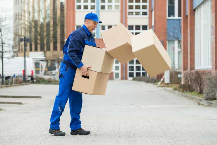 Delivery Man With Falling Stack Of Boxes