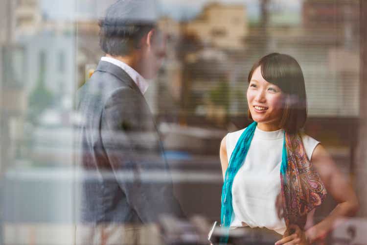 Japanese Business Man and Woman Meeting Viewed Through Office Window